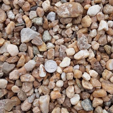 A pile of rocks with a quarter in the middle