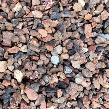 A pile of rocks with a quarter in the middle.