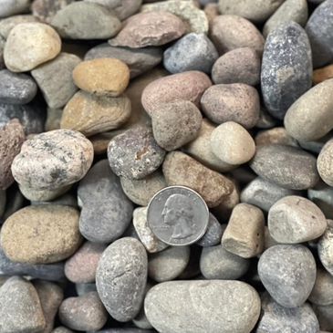 A pile of rocks with a quarter in the middle.
