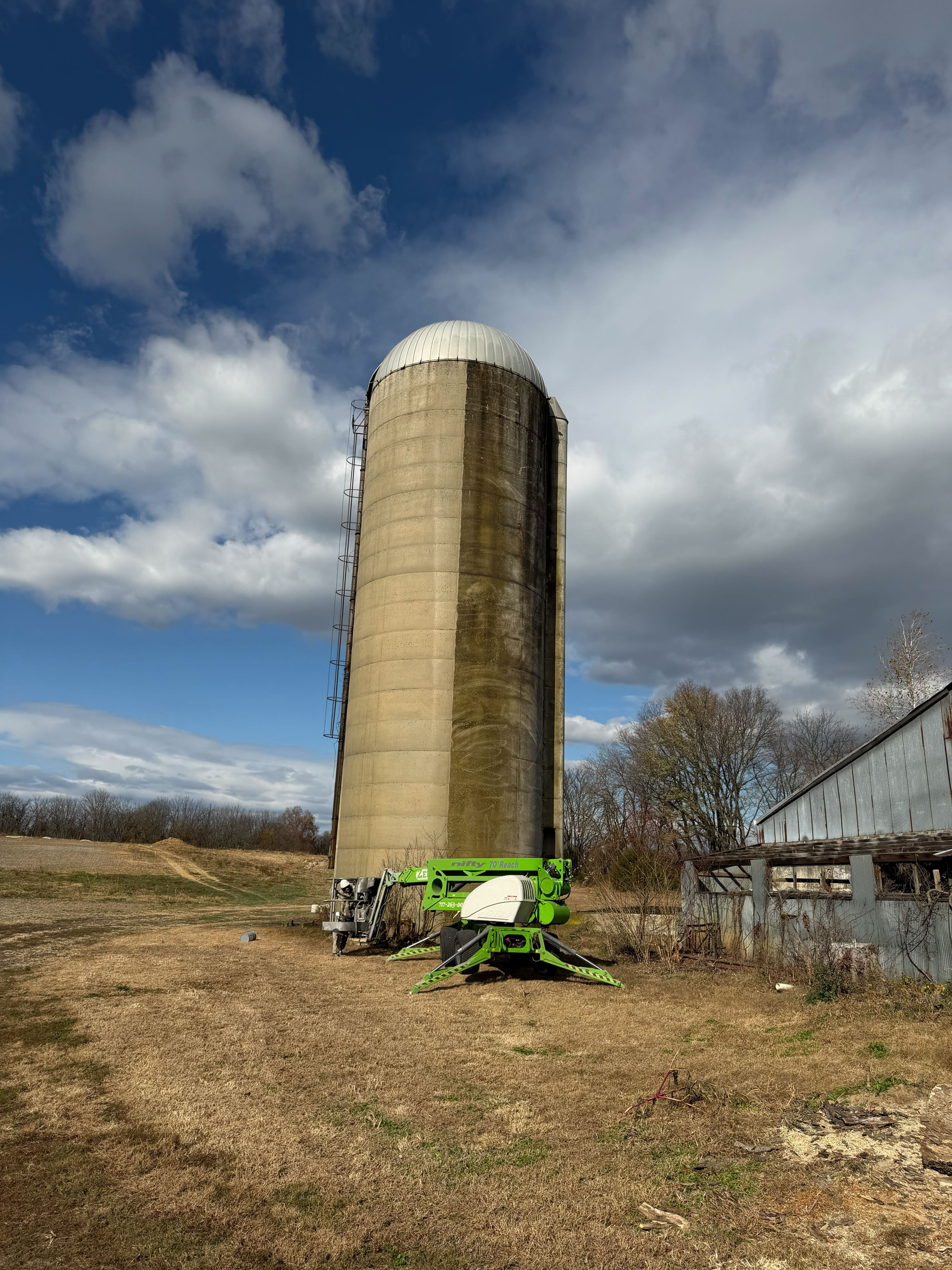 The before and after of power washing a concrete silo.