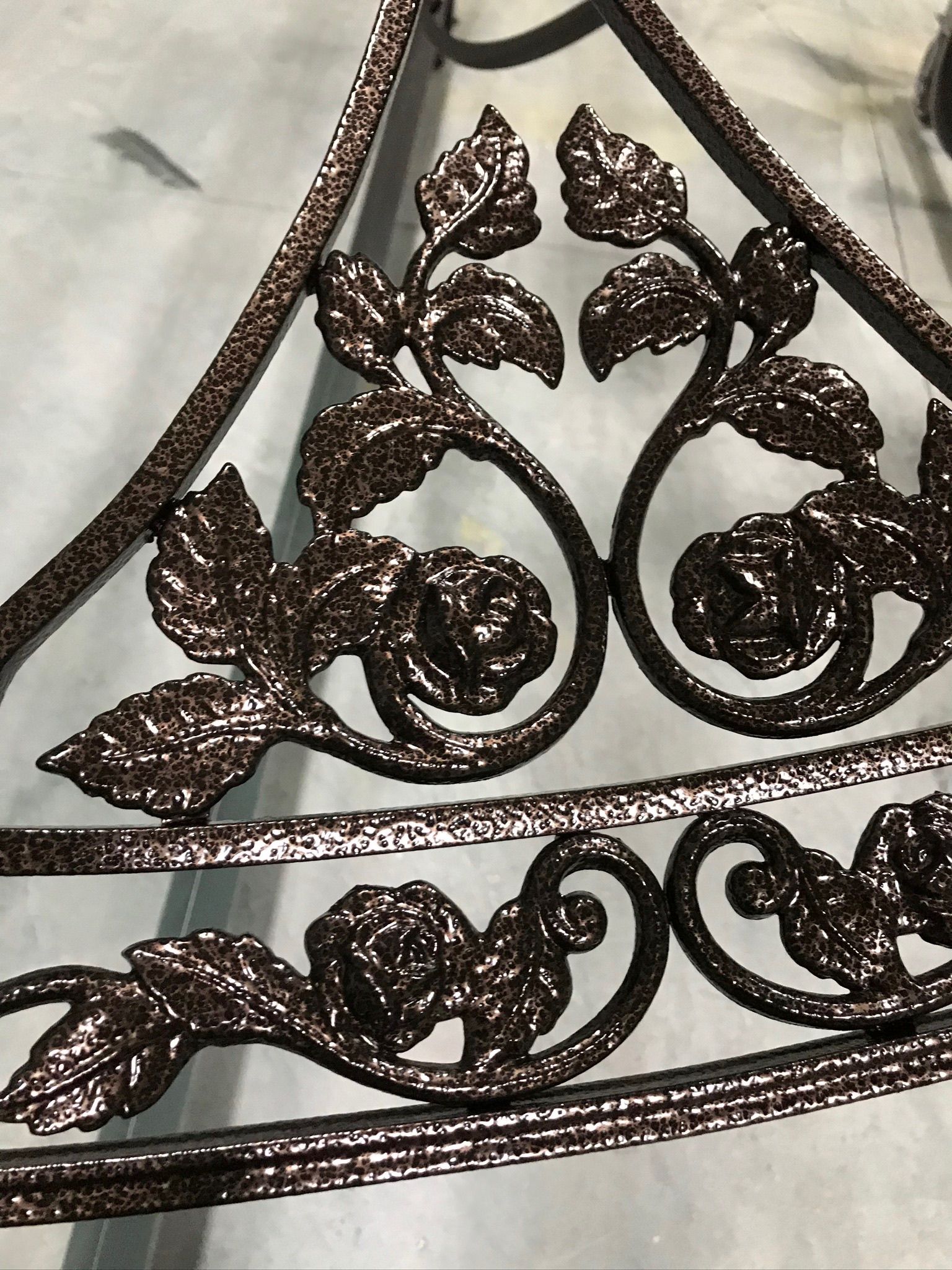 A close up of a wrought iron fence with leaves and swirls on it