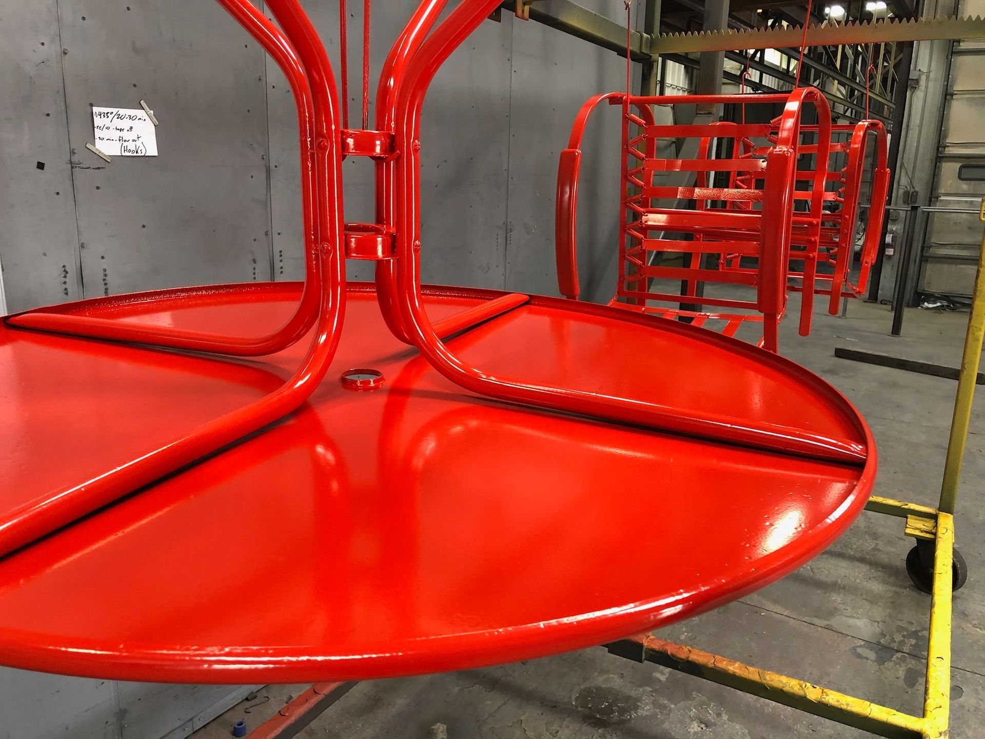 A red table is sitting on top of a yellow cart.
