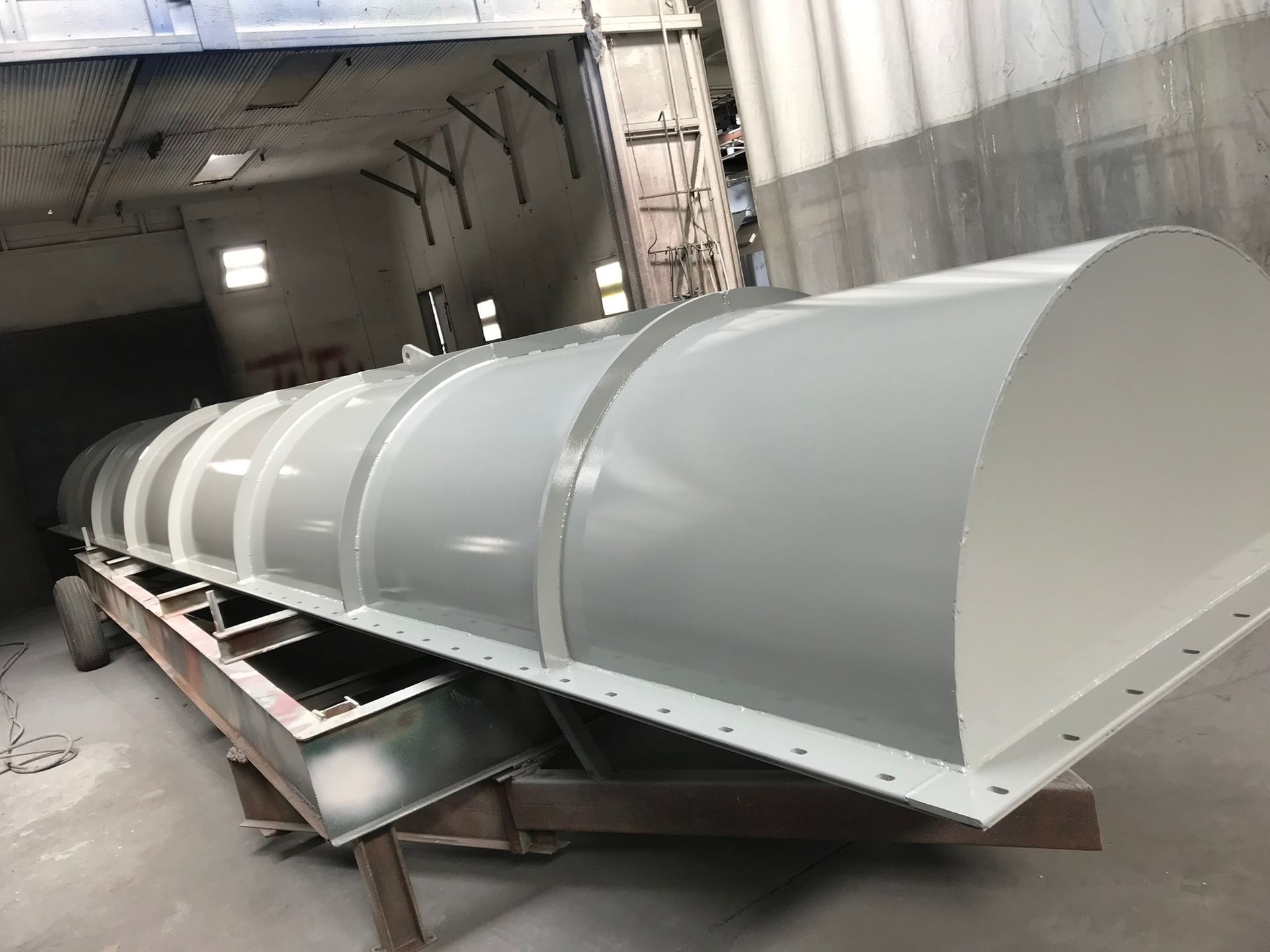 A large white object is sitting on top of a wooden table in a warehouse.