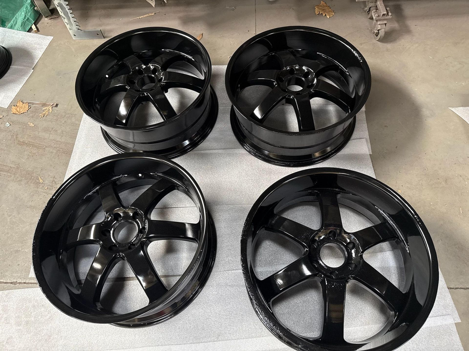 Four black wheels are sitting on top of each other on a piece of paper.