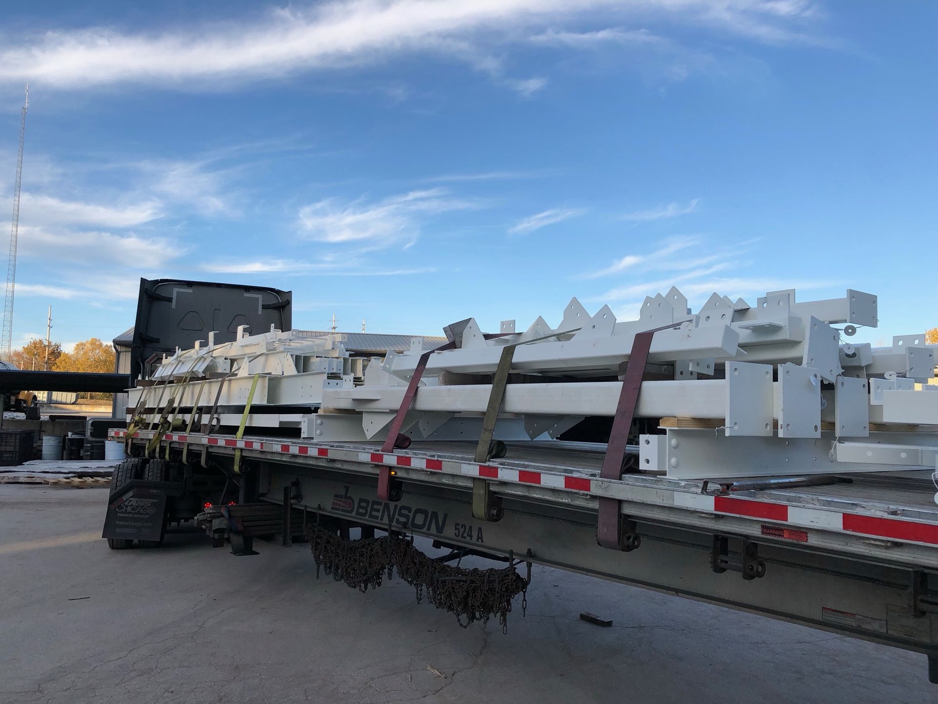A semi truck is loaded with a lot of white pieces of metal