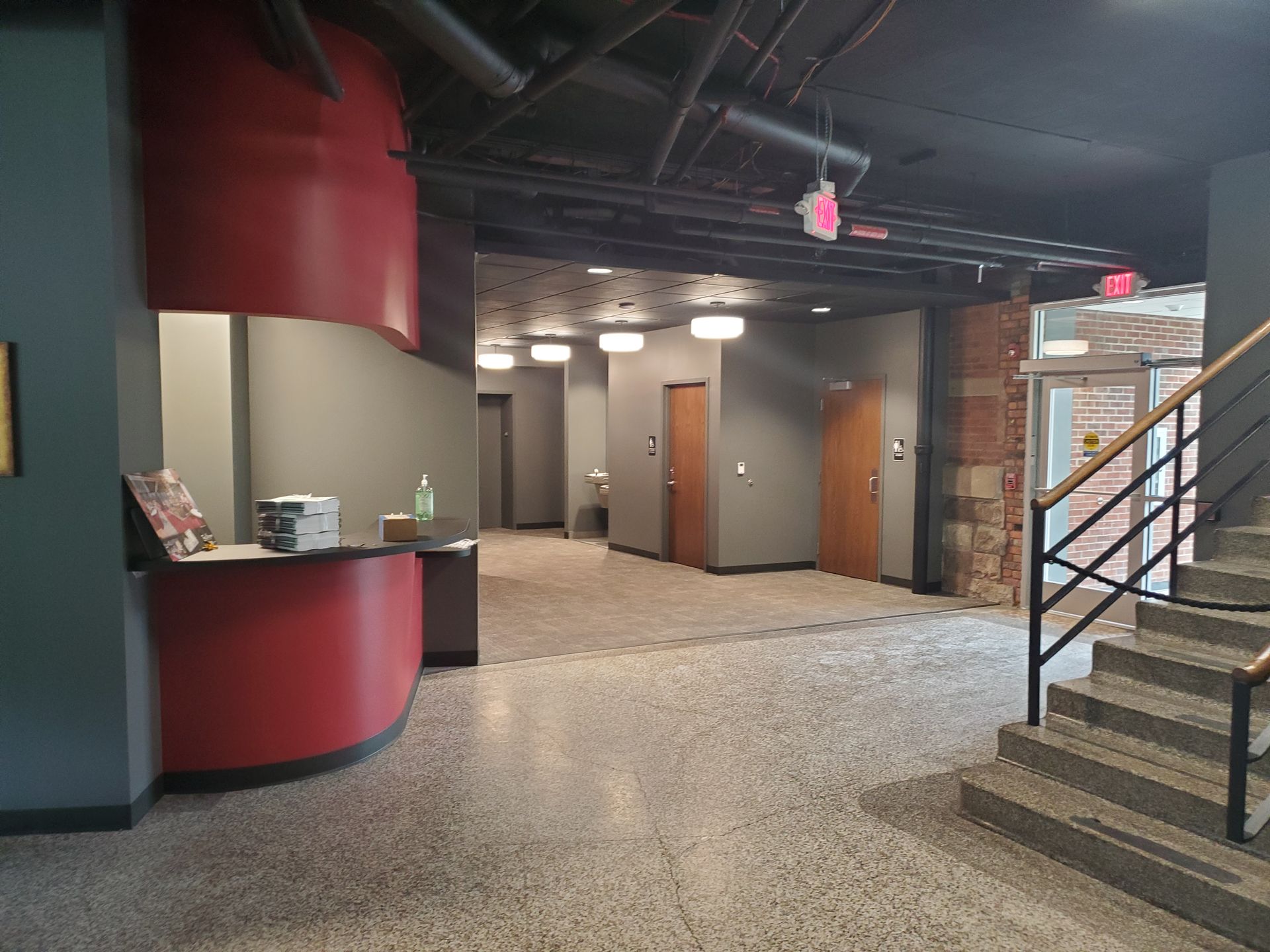 a lobby with a red counter and stairs in a building