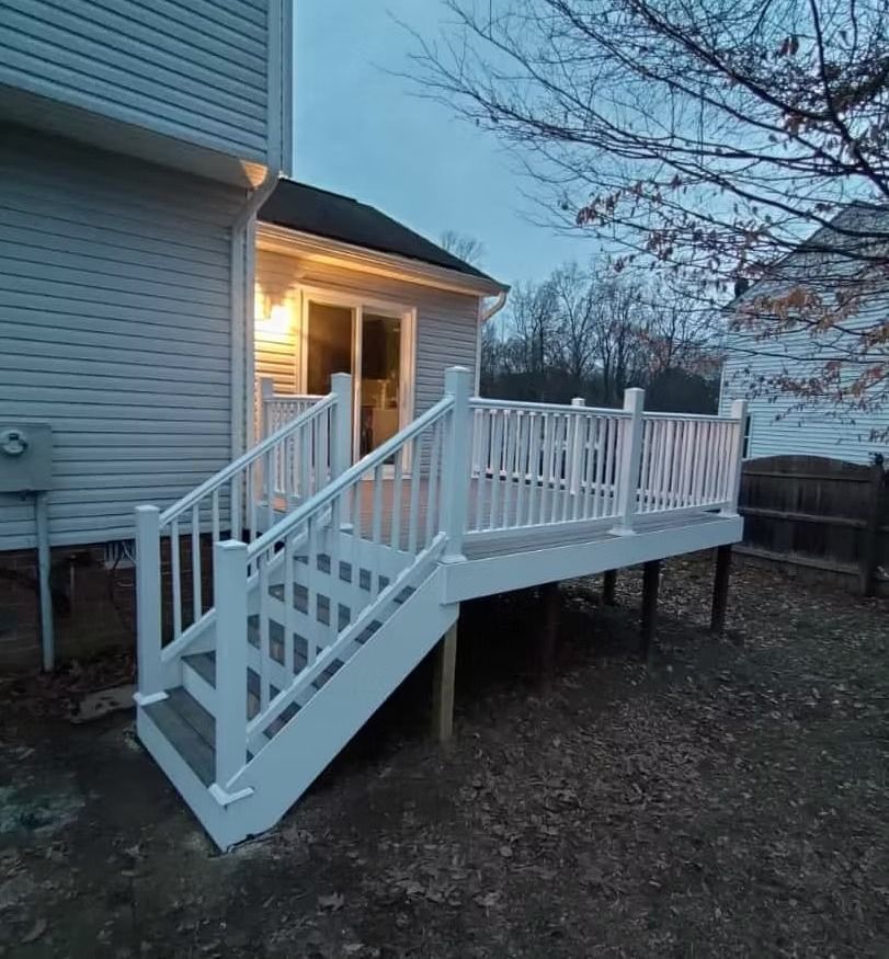 White wheelchair ramp with railings attached to a house at dusk