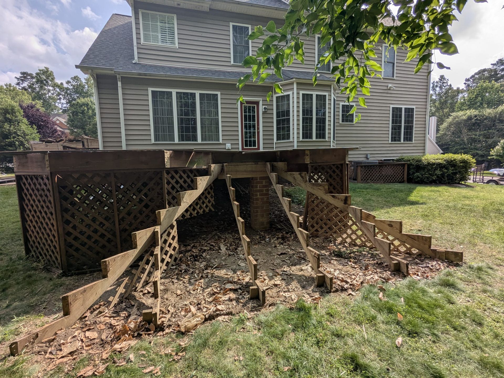 Raised deck on a house with a large collapsed section and exposed support posts underneath