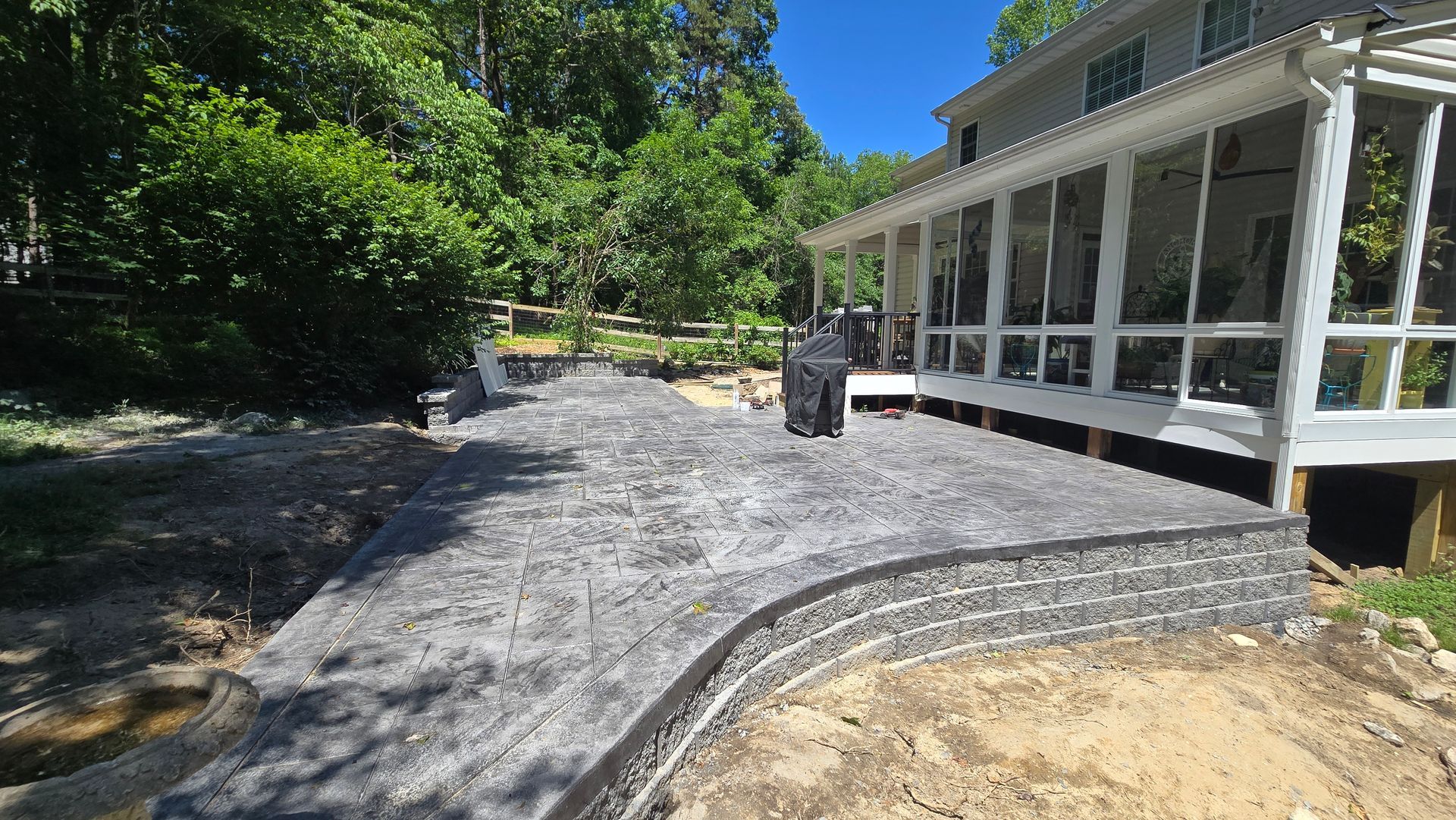 Gravel path beside a white house with screened porch, trees on the left, and a small utility vehicle ahead