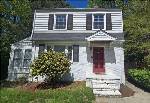 Two-story gray house with white trim, red door, and front steps in a sunny yard