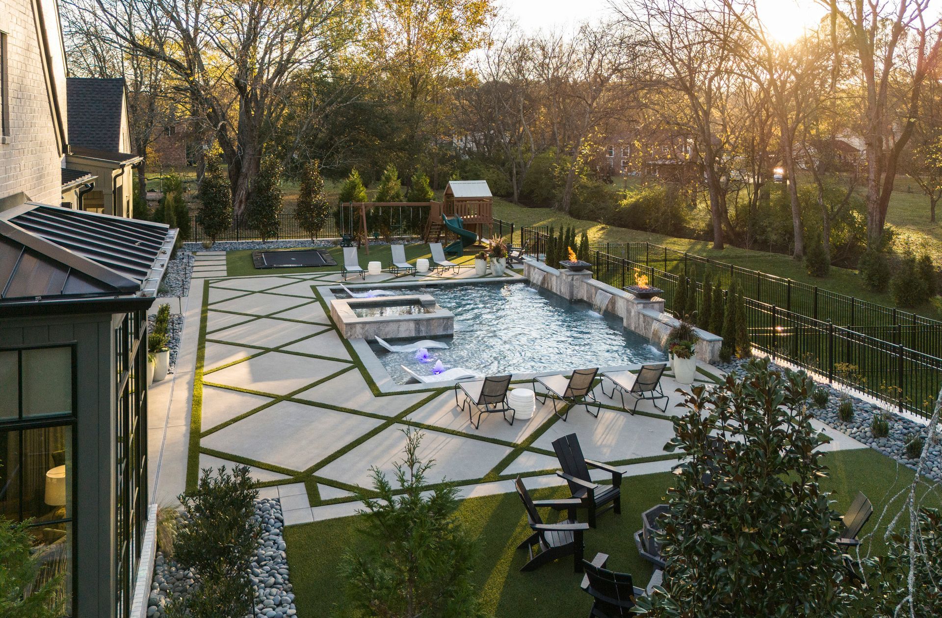 An aerial view of a backyard with a large swimming pool and chairs.