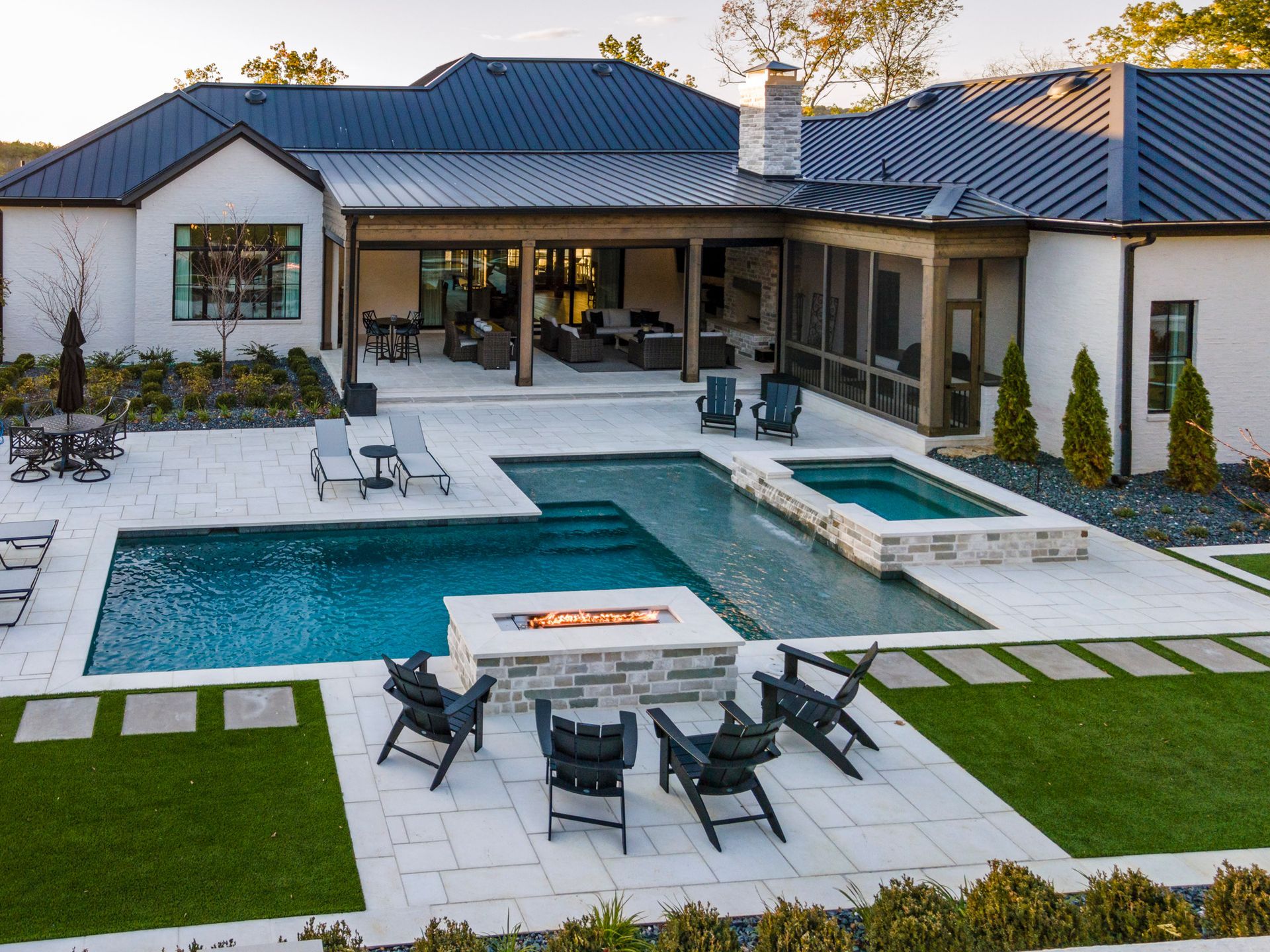 A large house with a large swimming pool and a fire pit