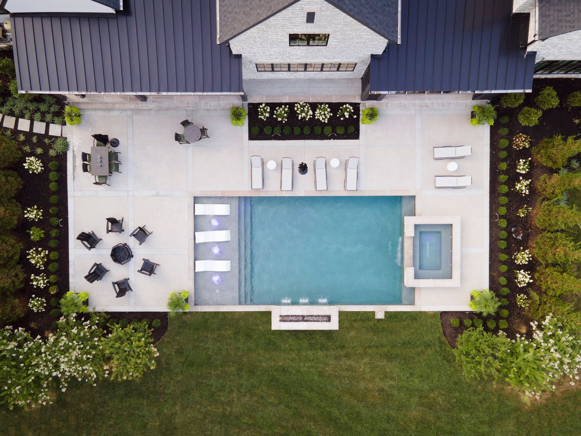 An aerial view of a house with a large swimming pool in the backyard.