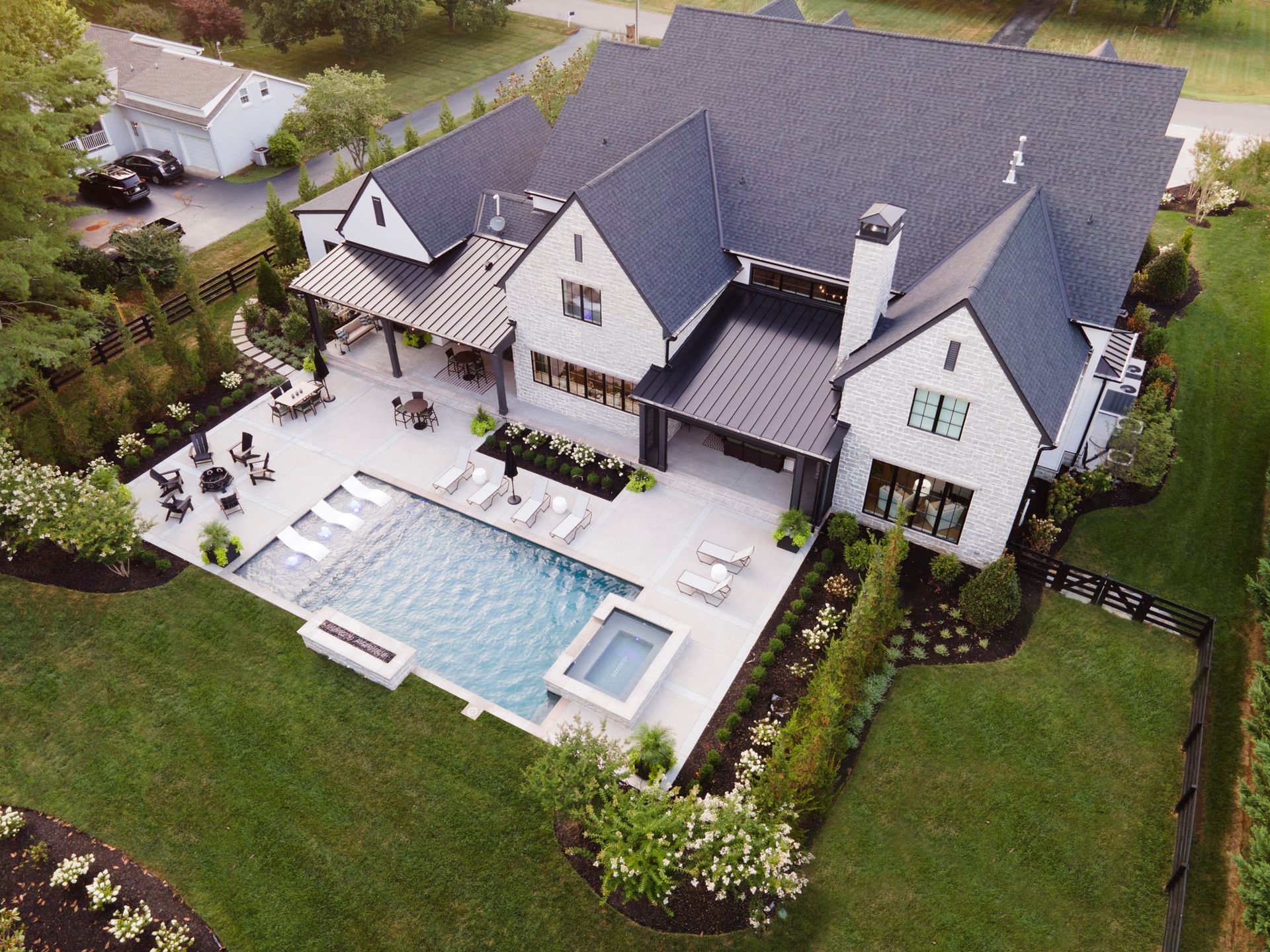 An aerial view of a large house with a swimming pool in the backyard.