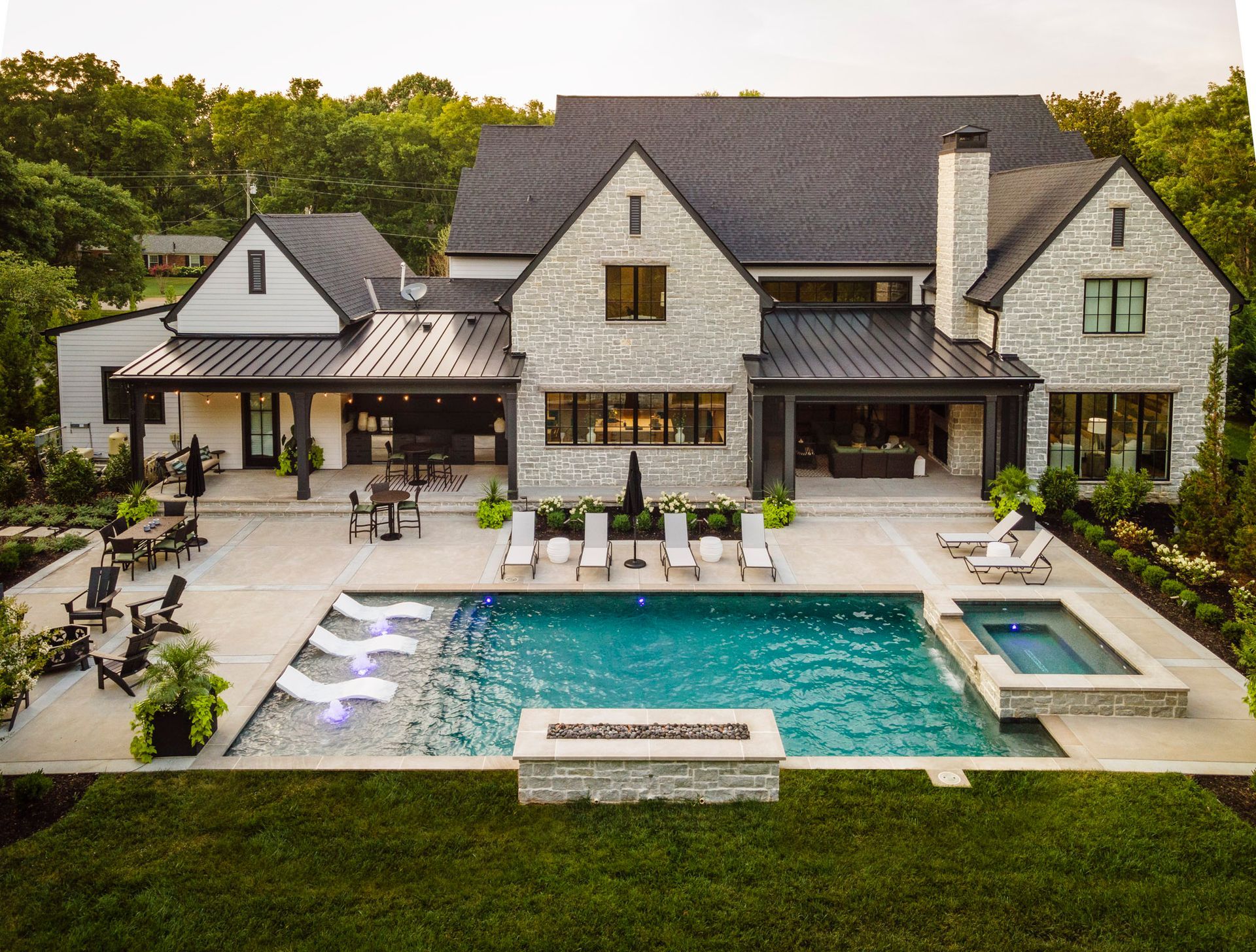 An aerial view of a large house with a large swimming pool