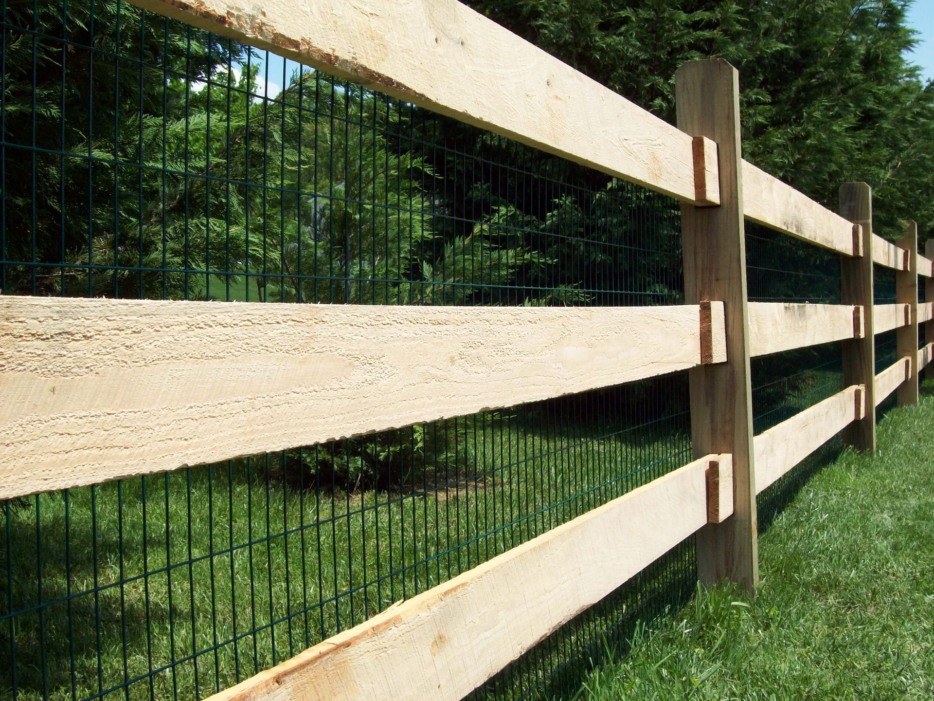 A wooden fence with a wire fence behind it