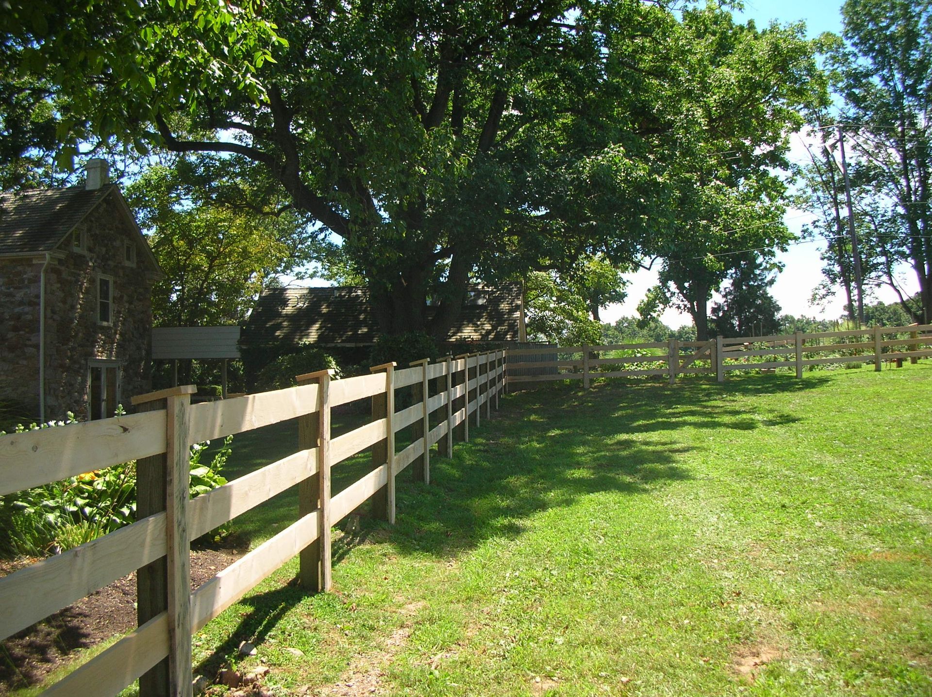 A wooden fence surrounds a lush green field
