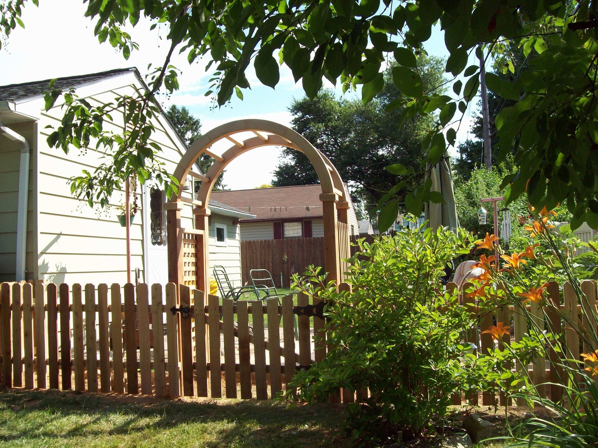 A wooden fence with a wooden arch in the backyard