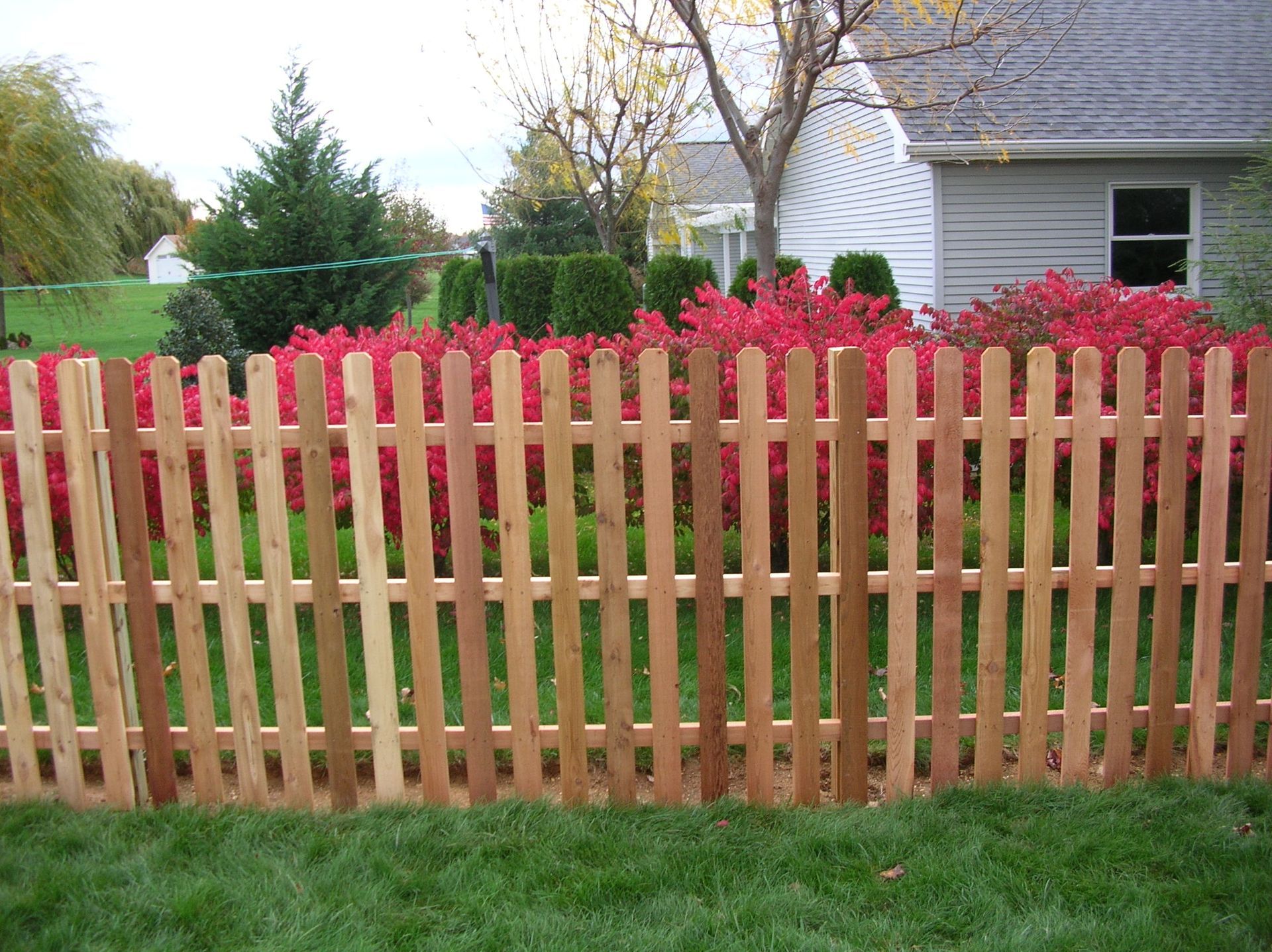A wooden picket fence in front of a house