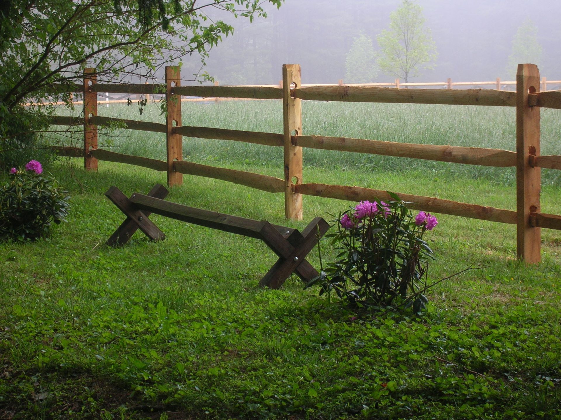 A wooden fence with a bench in front of it