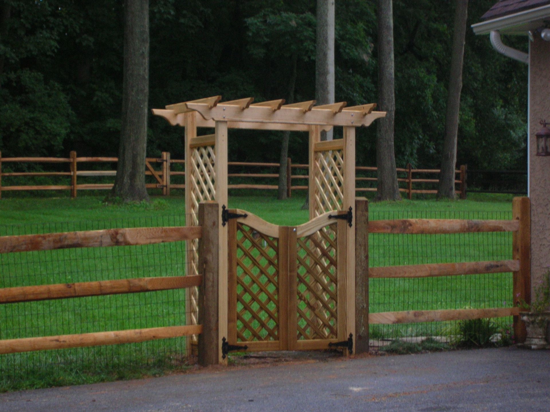 A wooden gate with a pergola on top of it