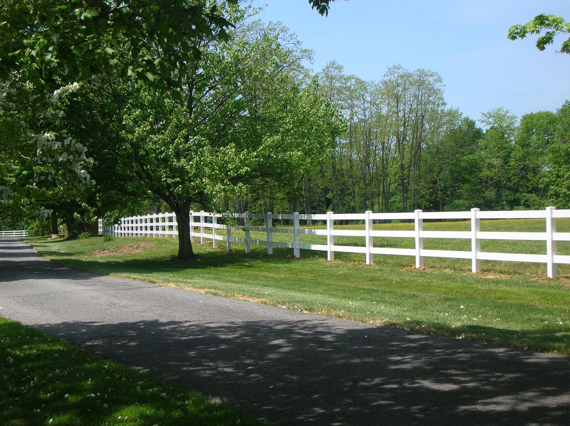 A white fence along the side of a road