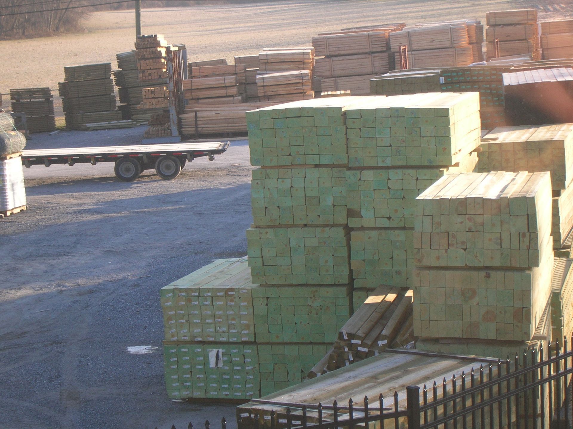 A large stack of green lumber is sitting in a yard