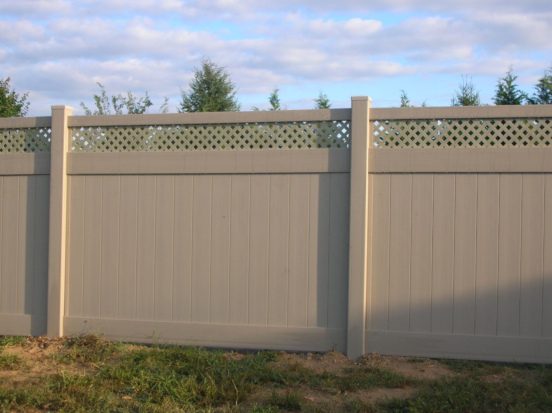 A white fence with a lattice design on the top