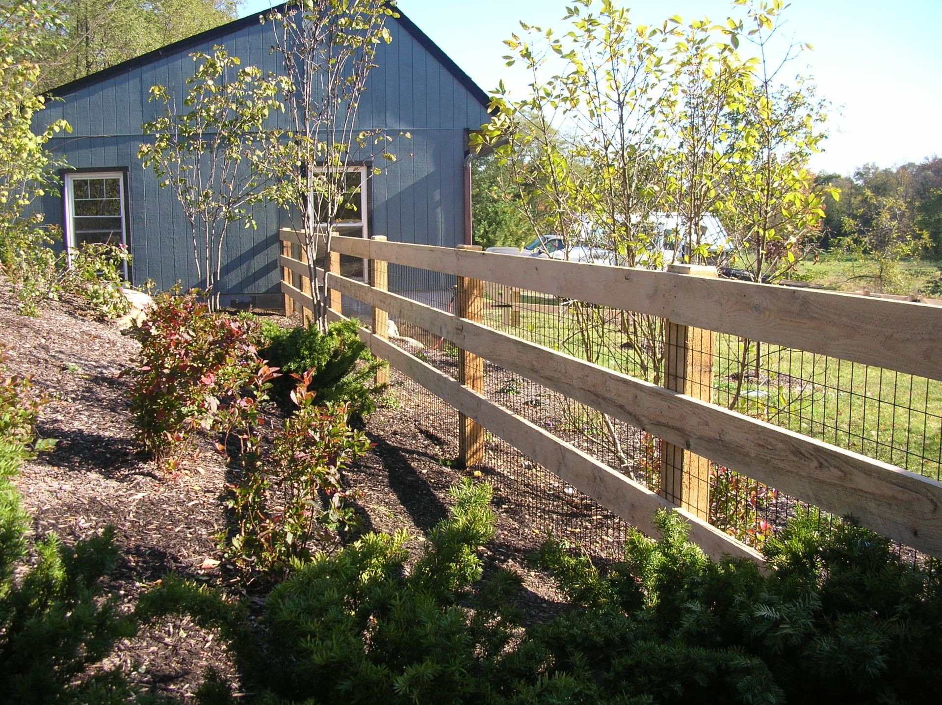 A wooden fence in front of a blue building