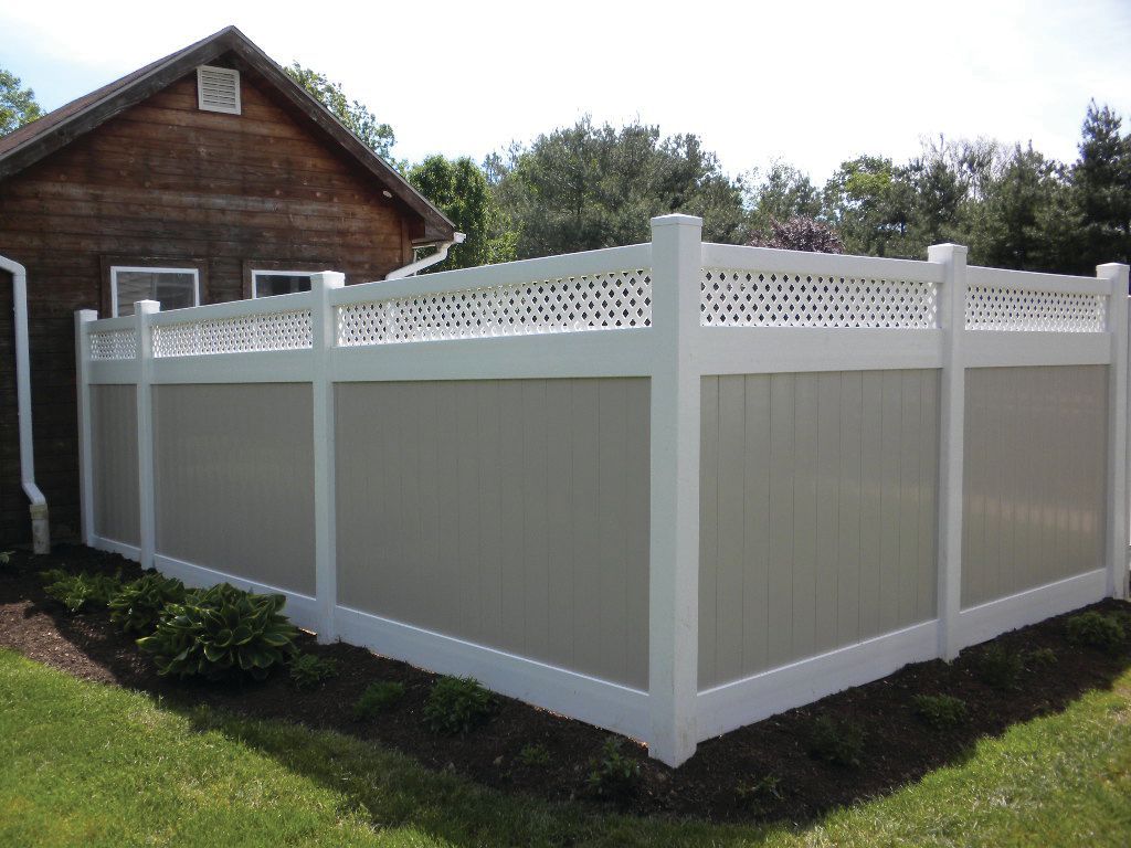 A white and gray fence is in front of a house