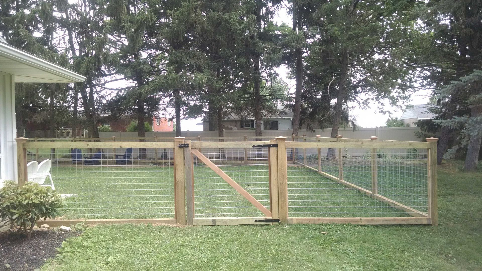 A wooden fence with a gate in the backyard of a house