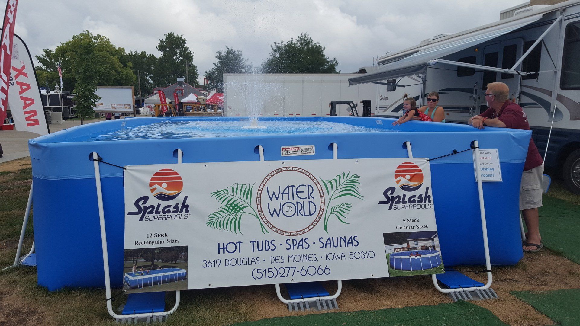 A man is standing next to a large pool with a sign that says water world