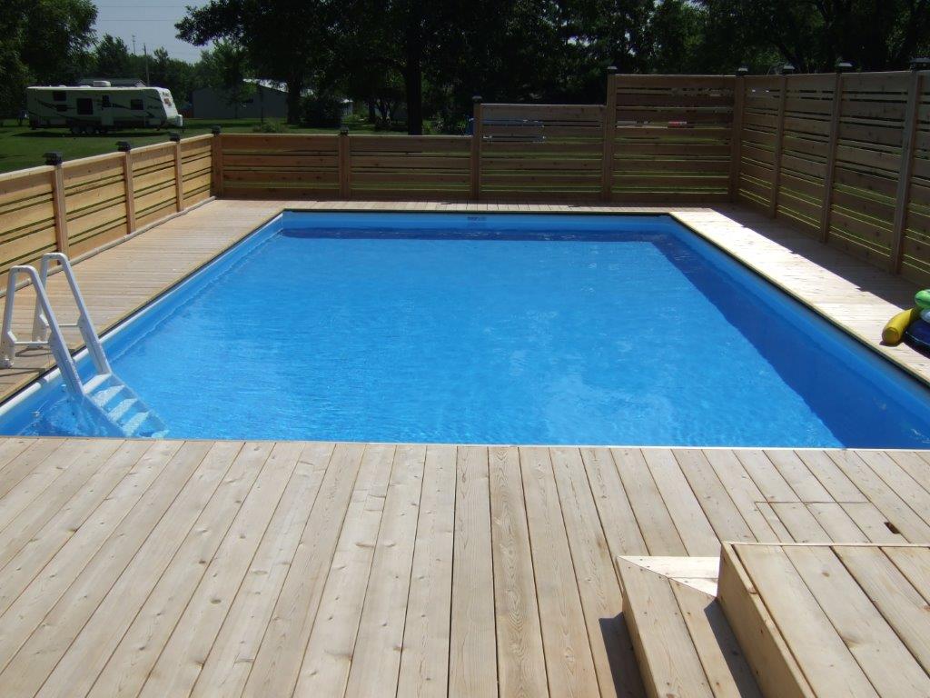 A large swimming pool surrounded by a wooden deck