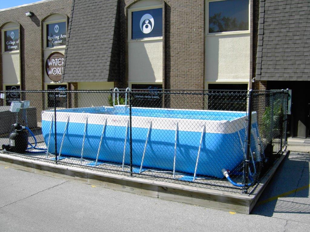 A large swimming pool is sitting outside of a building