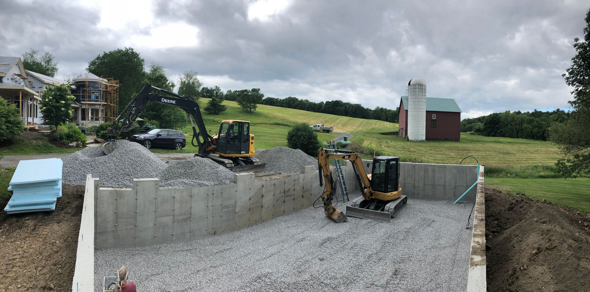 A construction site with a house in the background and a bulldozer in the foreground.