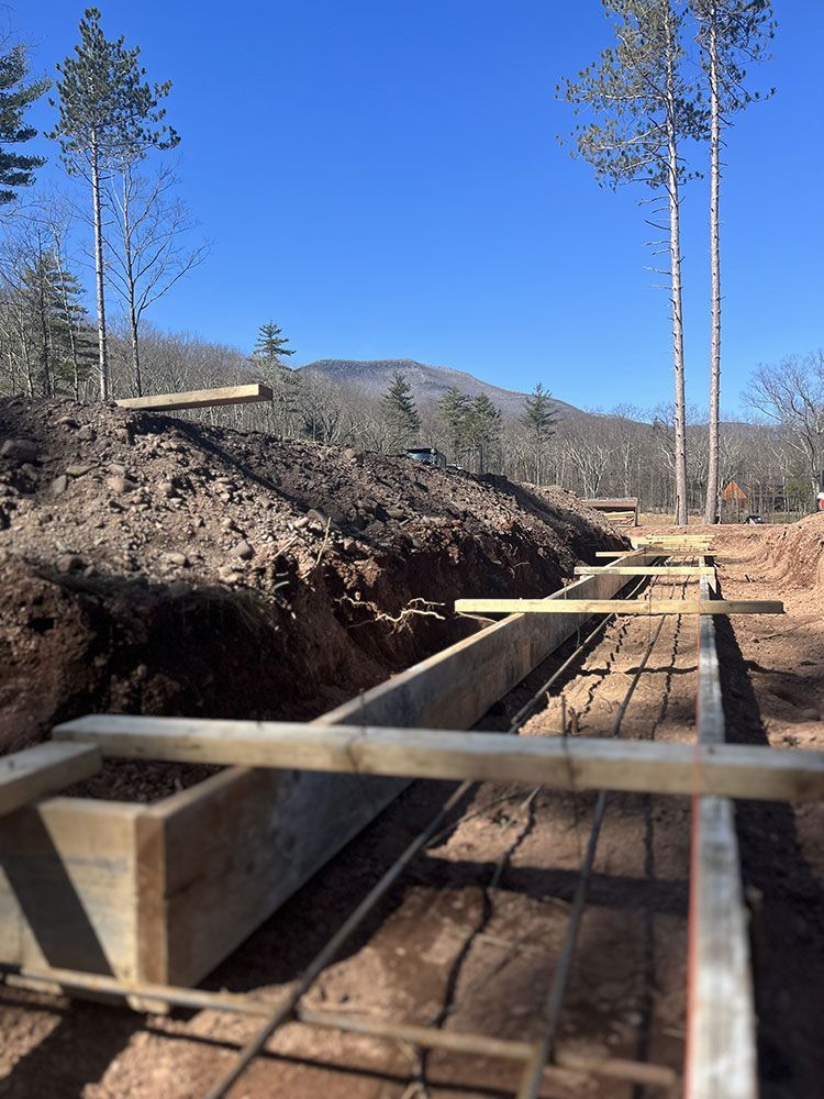 A construction site with trees in the background and a blue sky.