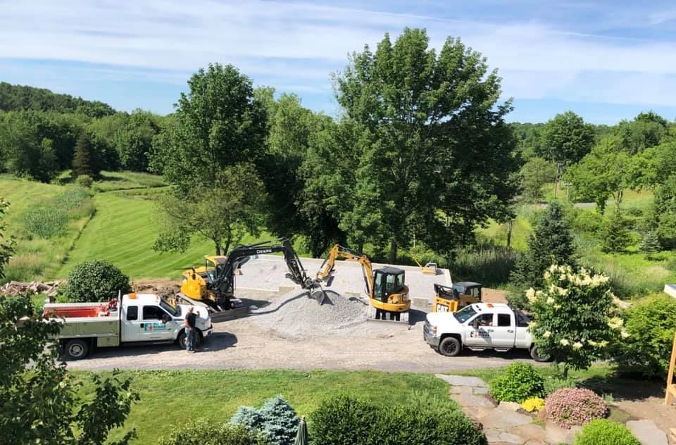 A group of construction trucks are parked in a driveway.