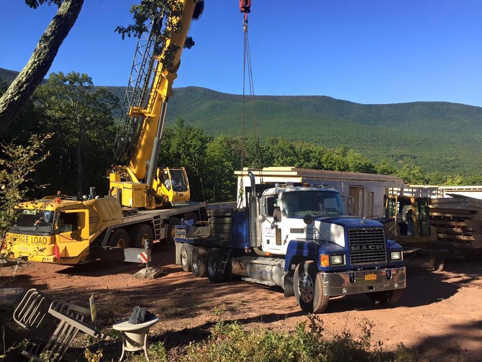 A mack truck is being lifted by a crane