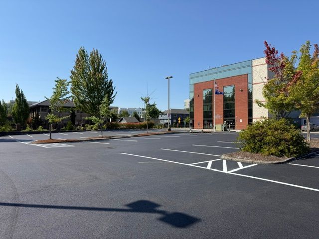 Empty parking lot beside a brick building on a sunny day