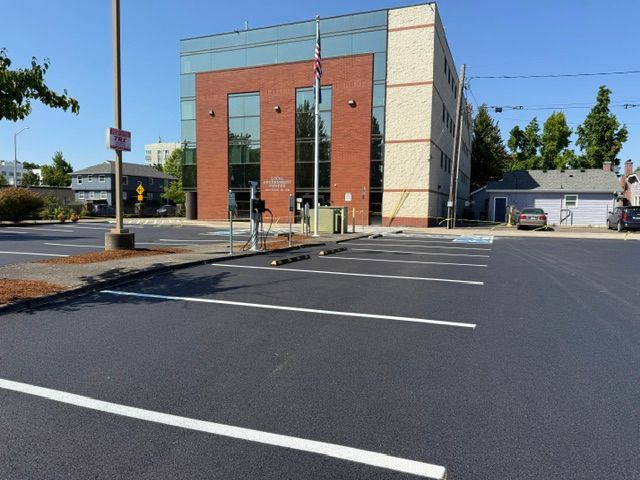 Empty parking lot beside a modern building under a clear blue sky