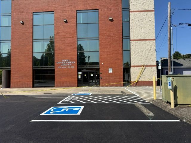 Brick building entrance with blue handicap parking space and accessible ramp on the right