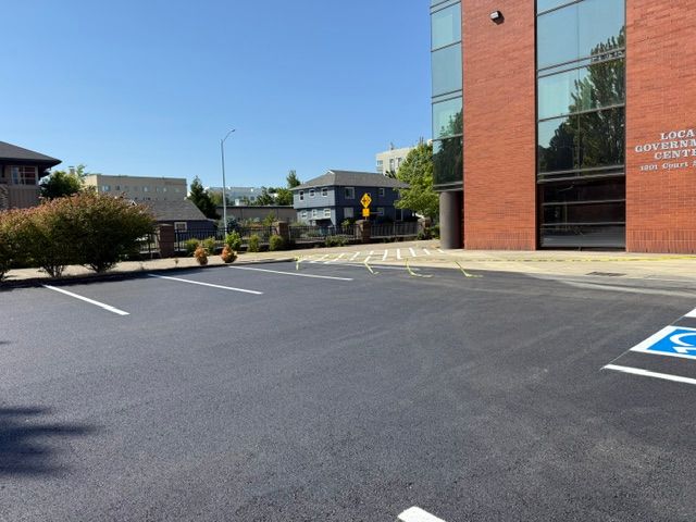 Empty parking lot beside a brick building on a sunny day