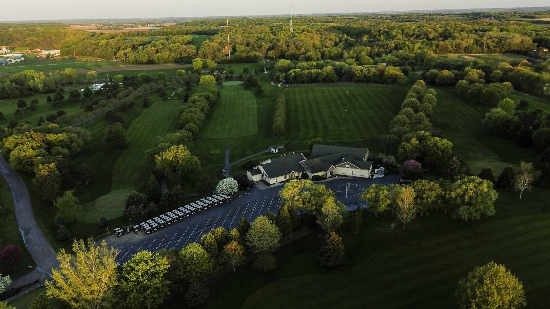 An aerial view of a golf course surrounded by trees and grass.