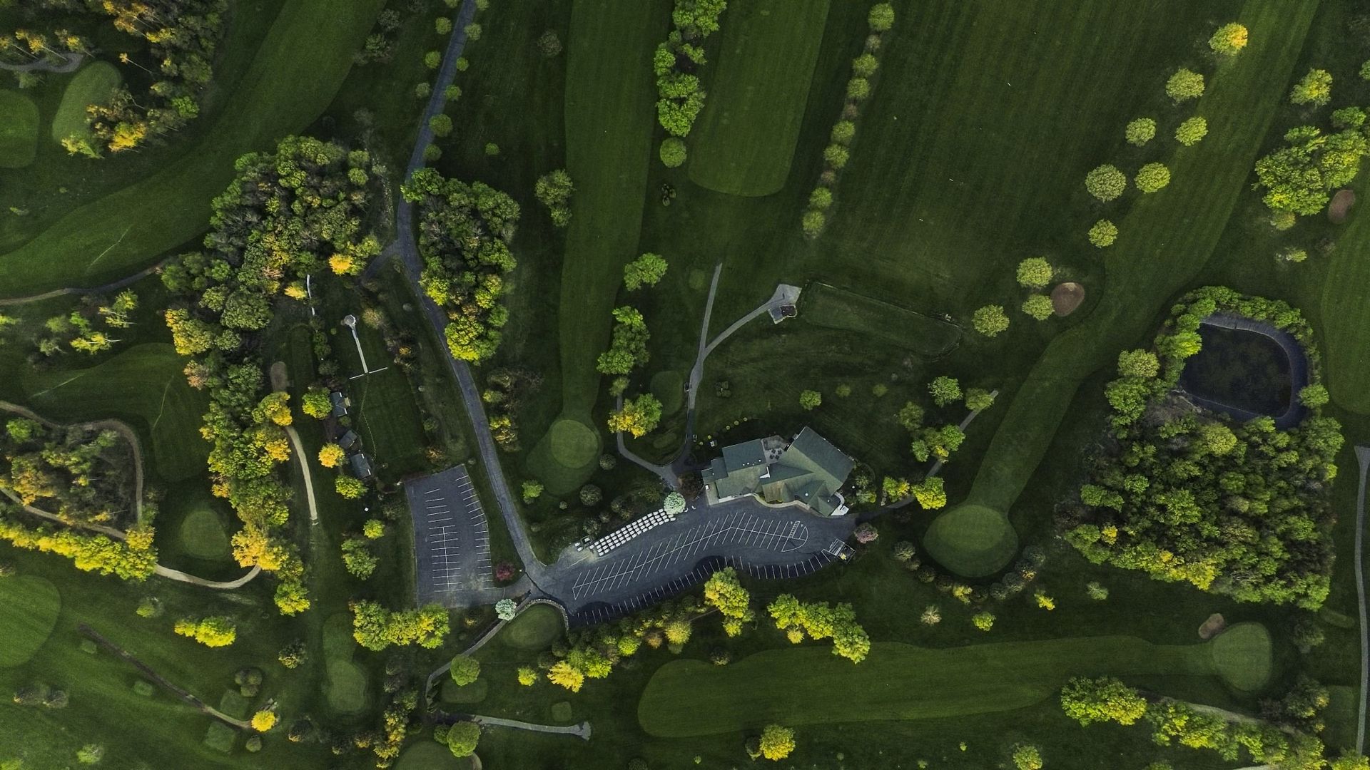 An aerial view of a golf course surrounded by trees.