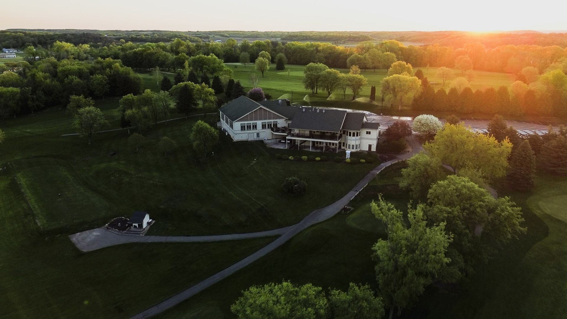 An aerial view of a house surrounded by trees and grass.