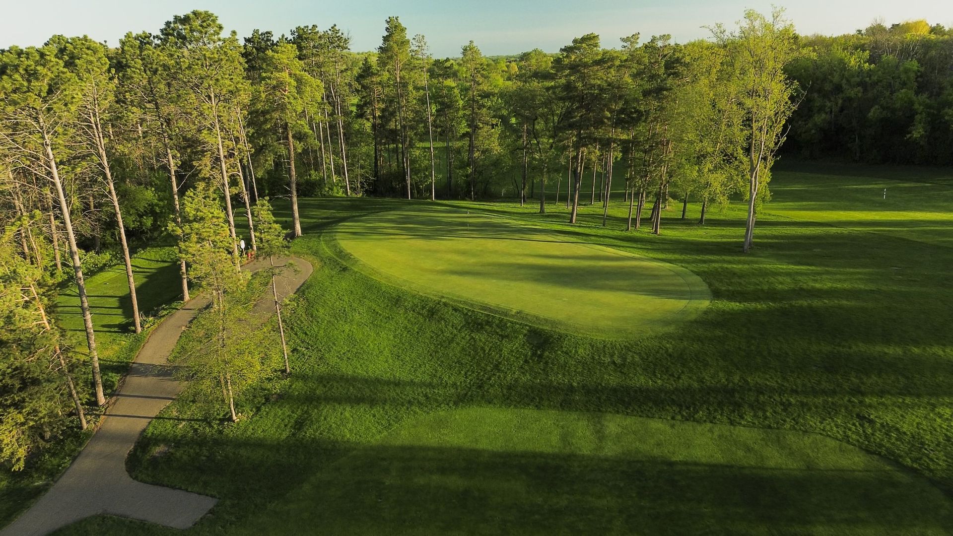 An aerial view of a golf course surrounded by trees.