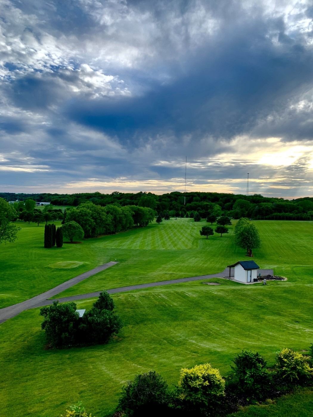 An aerial view of a golf course with a cloudy sky in the background.