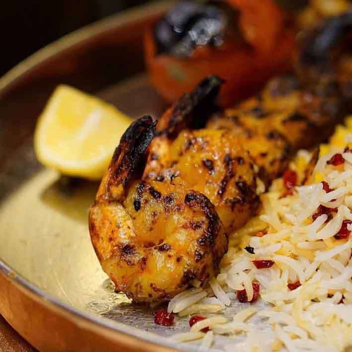 A close up of a plate of food with shrimp and rice.
