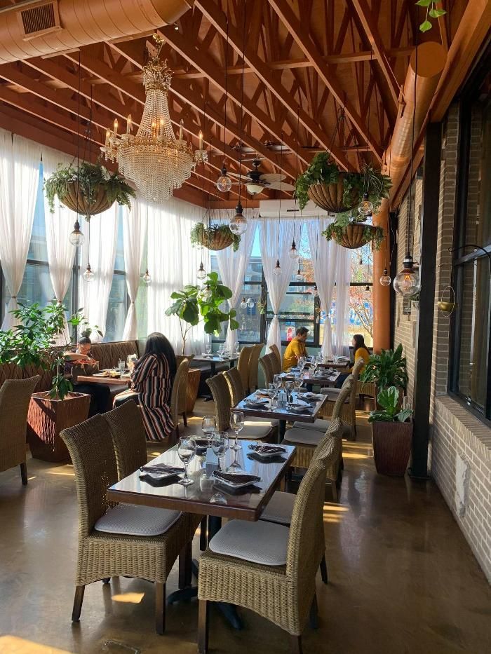 A restaurant with tables and chairs and a chandelier hanging from the ceiling.