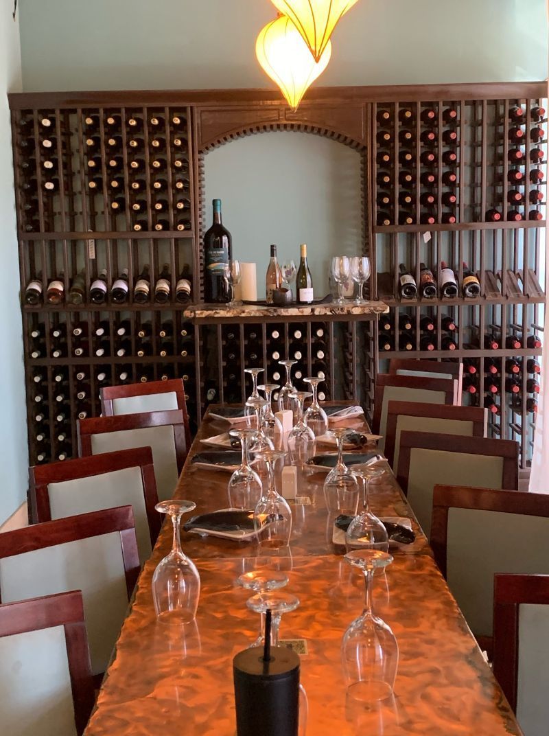 A long table with a lot of wine glasses on it